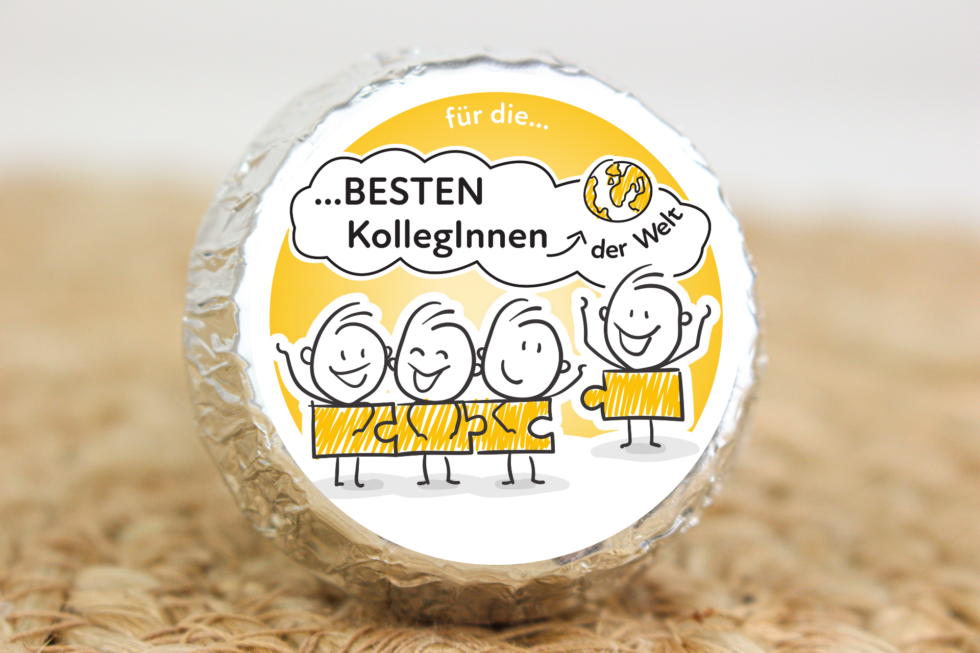 Silber verpackter Schokotaler mit Strichmännchen-Team und Aufschrift „Für die besten KollegInnen der Welt“