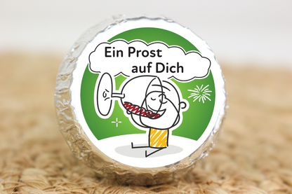Silber verpackter Schokotaler mit anstoßendem Strichmännchen und Aufschrift „Ein Prost auf Dich“