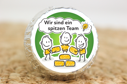 Silber verpackter Schokotaler mit Strichmännchen-Team und Aufschrift „Wir sind ein spitzen Team“