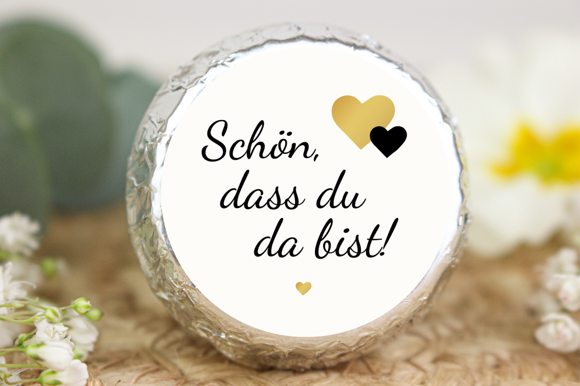 Silber verpackter Schokotaler mit knuspriger Waffel, Haselnusscreme, Herzmotiven und Aufschrift „Schön, dass du da bist!“