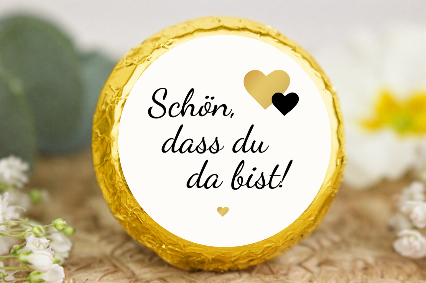 Gold verpackter Schokotaler mit knuspriger Waffel, Karamellcreme, Herzmotiven und Aufschrift „Schön, dass du da bist!“